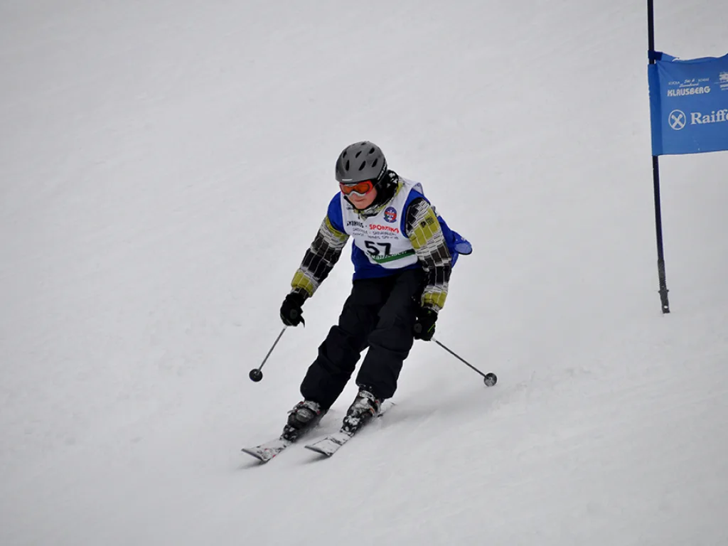 Skifahrer mit Startnummer 57 in der Kurve.